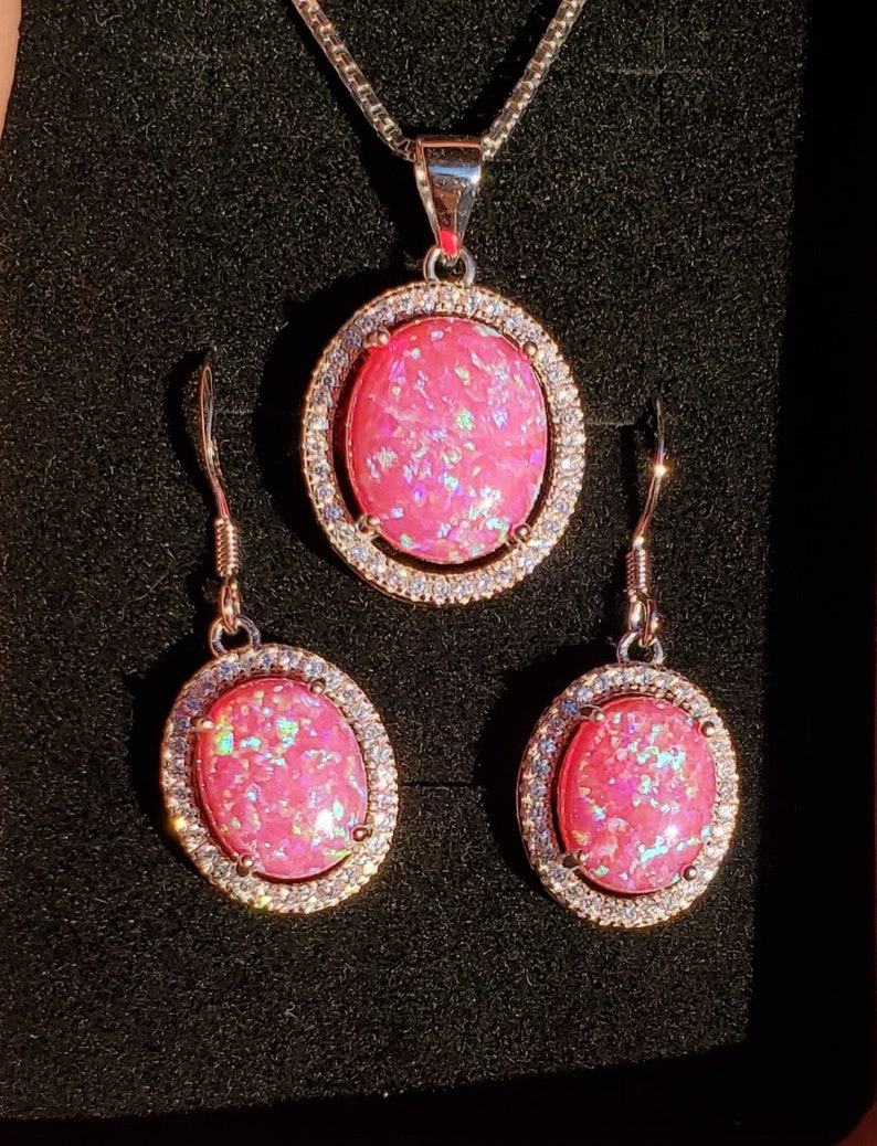 Puede incluir: Un collar con colgante de &oacute;palo rosa y un juego de pendientes a juego con una cadena de plata y detalles de circonita c&uacute;bica transparente.