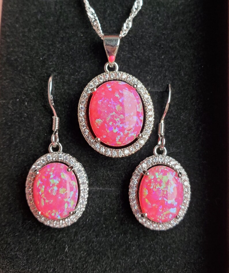 Puede incluir: Un conjunto de collar y pendientes de &oacute;palo rosa con cadena de plata y engastes de plata con piedras de circonita c&uacute;bica transparentes.