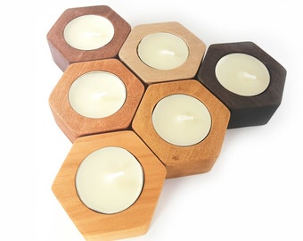 May include: Six wooden hexagonal candle holders in various shades of brown, arranged in a honeycomb pattern. Each holder has a small, round, white candle inside.