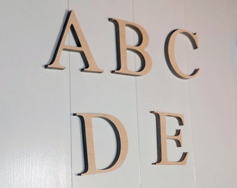May include: Wooden letters spelling out the word "ABCDE" in a simple, sans-serif font. The letters are painted a light brown color and have a slightly distressed look.