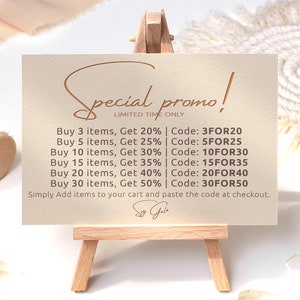 May include: A beige card with a handwritten "Special promo!" in brown script. The card lists discounts for buying multiple items, with codes for each discount. The text reads: "Buy 3 items, Get 20% | Code: 3FOR20, Buy 5 items, Get 25% | Code: 5FOR25, Buy 10 items, Get 30% | Code: 10FOR30, Buy 15 items, Get 35% | Code: 15FOR35, Buy 20 items, Get 40% | Code: 20FOR40, Buy 30 items, Get 50% | Code: 30FOR50. Simply Add items to your cart and paste the code at checkout."