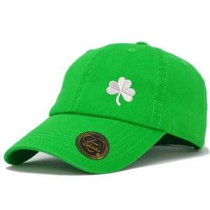 May include: A green baseball cap with a white embroidered shamrock. The cap has a curved brim and an adjustable strap.
