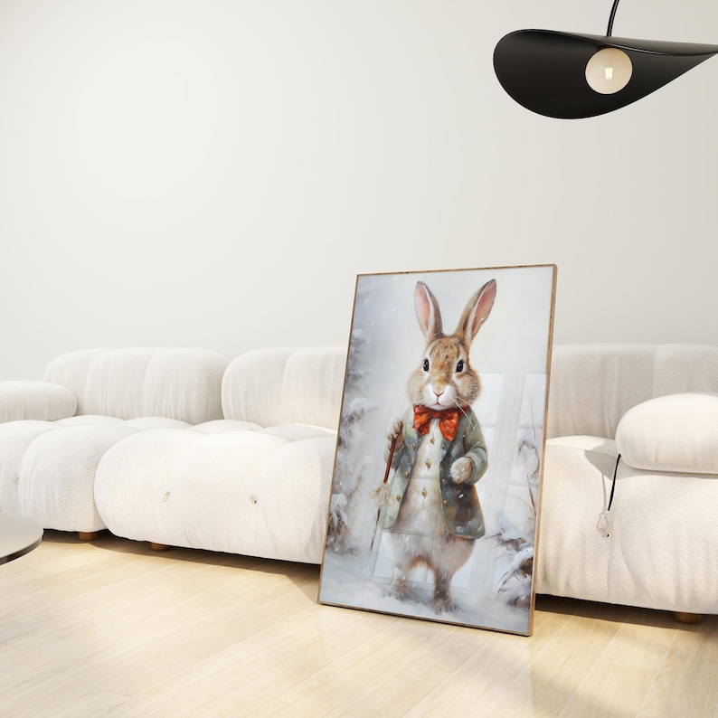 May include: A framed painting of a brown rabbit wearing a green coat and a red bow tie. The rabbit is standing in a snowy woodland setting.