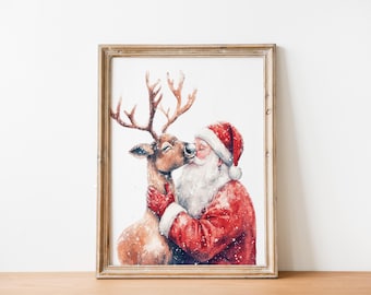 May include: A framed watercolor print depicts Santa Claus kissing a reindeer. Santa wears a red suit and hat with white trim, and the reindeer has large antlers. The artwork is set against a white background, with a wooden frame.