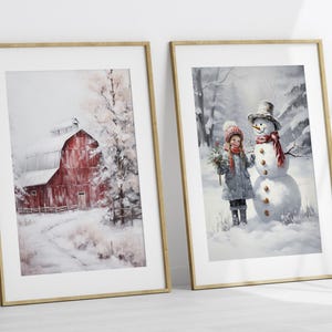May include: Two framed winter-themed paintings. The first painting shows a red barn in a snowy landscape. The second painting shows a girl in a red hat and blue coat standing next to a snowman.