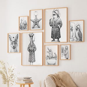 May include: A collection of framed black and white illustrations featuring anthropomorphic animals in various bathroom settings. The artwork includes a fox with a toilet paper roll on its head, a giraffe in a robe, and a shark drinking coffee.