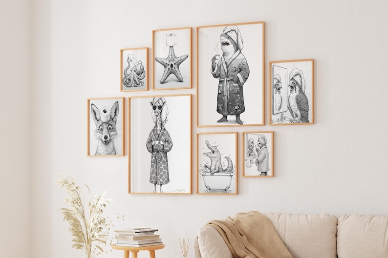 May include: A collection of framed black and white illustrations featuring anthropomorphic animals in various bathroom settings. The artwork includes a fox with a toilet paper roll on its head, a giraffe in a robe, and a shark drinking coffee.