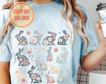 May include: A light blue t-shirt with a floral pattern of bunnies. The shirt has the text "COMFORT COLORS!" in a circle on the top left corner.