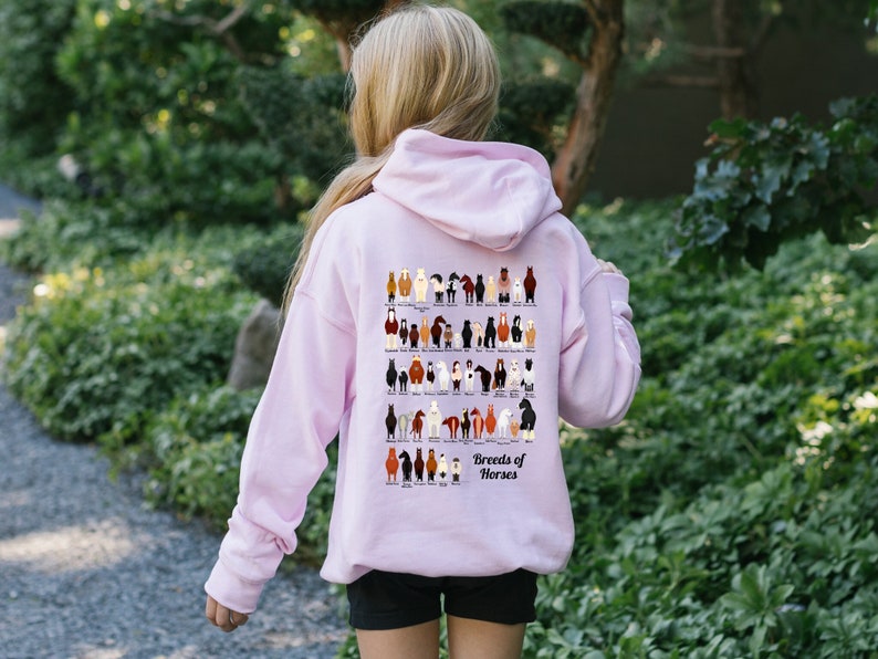 May include: A pink hoodie with a graphic of different horse breeds on the back. The graphic is titled "Breeds of Horses".