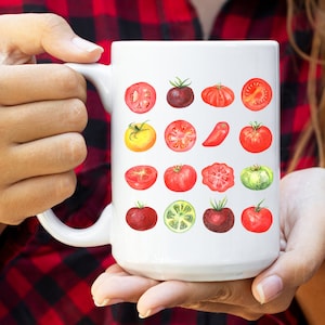 May include: White ceramic mug with a colorful watercolor illustration of various types of tomatoes, including red, yellow, green, and purple varieties.