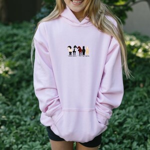 May include: A pink hoodie with a graphic of five horses in a row. The horses are black, brown, white, and gray. The text below the horses reads "Always Sparkle, Never Fade".