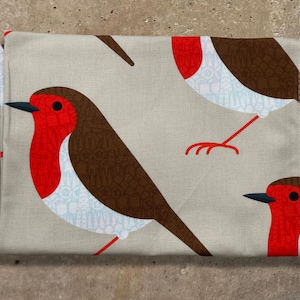 May include: A folded, rectangular fabric item with a repeating pattern of stylized robins. The birds feature red breasts, brown wings, and black beaks against a beige background. The robin's legs are a bright orange-red colour.