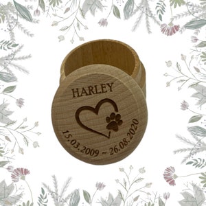 May include: A small wooden box with a heart and paw print design. The box is engraved with the name "HARLEY" and the dates "15.03.2009 - 26.08.2020".