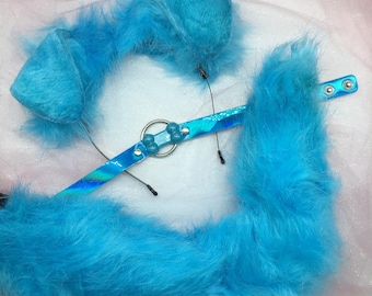 May include: A blue faux fur tail, a blue faux fur headband with ears, and a blue iridescent choker with silver accents.