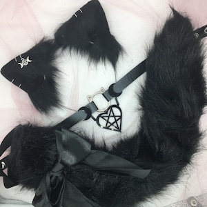 May include: Black faux fur cat ears headband with a black choker and a silver pentagram charm. The choker has a black satin bow.