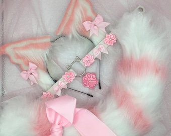 Pode incluir: Faixa de cabeça de orelhas de gato de pele sintética rosa e branca com um amuleto de gato prateado e detalhes de flores rosa. Uma cauda combinando de pele sintética rosa e branca com um laço de cetim rosa.