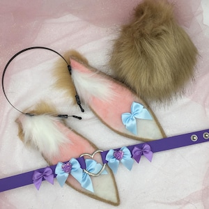 May include: A set of cosplay accessories featuring pink and white faux fur ears with light blue bows and a purple collar. A fluffy brown tail and a black headband complete the set. The ears have a heart-shaped accent.