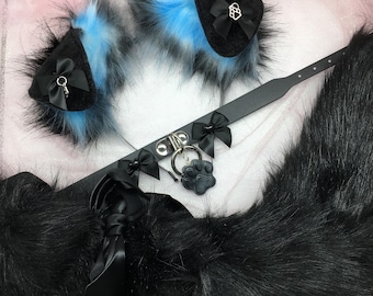 May include: A black faux fur tail with a black choker and two blue and black faux fur ears. The choker has a silver charm with a paw print.