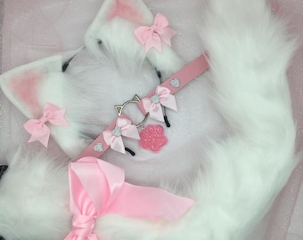 May include: White faux fur cat ears and tail with pink bows and a pink choker with a silver paw charm.