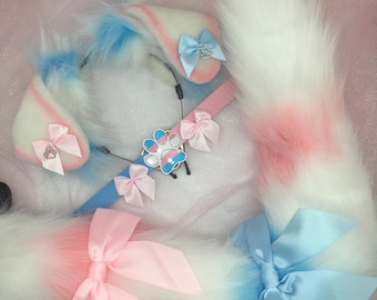 May include: A set of two fluffy white and pink tails with blue tips and bows, and a white headband with blue and pink ears and a paw print charm.