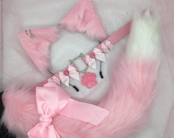 Puede incluir: Un conjunto de orejas de gato, collar y cola de piel sintética rosa. Las orejas tienen aros plateados y el collar presenta un dije de oreja de gato, lazos rosas y un colgante de huella de pata. La cola es rosa con una punta blanca y un lazo rosa grande.