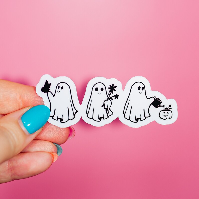 May include: Four white ghost stickers on a pink background. The ghosts are in a line and each one is doing a different activity. The first ghost is holding a butterfly, the second ghost is holding a flower, the third ghost is holding a watering can, and the fourth ghost is watering a pumpkin.