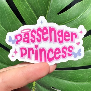 May include: Pink and white sticker with the text "Passenger Princess" in a pink bubble font. The sticker has two small blue butterflies and two pink hearts.