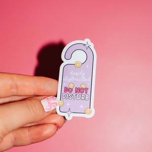 May include: Purple door hanger sticker with the text "Easily distracted. Do Not Disturb" and smiley faces around the text.