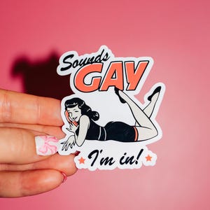 May include: A white sticker with a black and red illustration of a woman on the phone. The text "Sounds Gay I'm in!" is printed on the sticker.