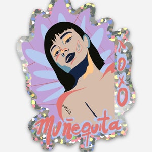 May include: A sticker with a colorful illustration of a woman with a black bob haircut and a pink, blue, and yellow background. The sticker has a glittery finish and the text "Muñequita" in pink and white letters.