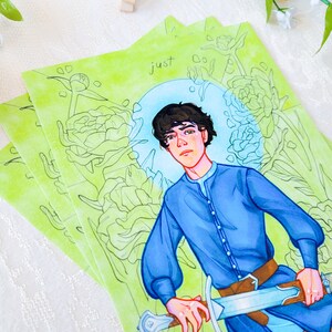 May include: A watercolor illustration of a young person with short brown hair wearing a blue shirt and holding a sword. The background is a green and white floral pattern with the word "just" written in the top center of the image.