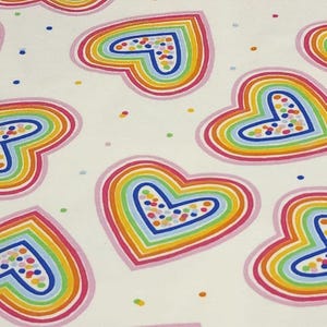 K&ouml;nnte beinhalten: Ein sich wiederholendes Muster aus regenbogenfarbenen Herzen auf wei&szlig;em Hintergrund. Jedes Herz ist rosa umrandet und mit konzentrischen Farbb&ouml;gen gef&uuml;llt. Die Zentren der Herzen sind mit bunten, konfettiartigen Punkten gef&uuml;llt. Kleine Farbpunkte sind um die Herzen herum verstreut.
