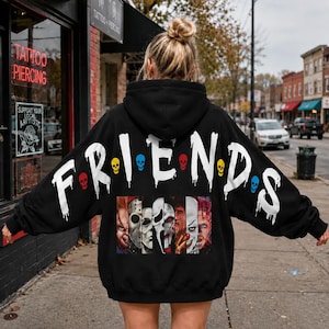May include: A black hooded sweatshirt featuring the word FRIENDS in large white dripping letters across the back. Small colorful skulls replace the dots between letters. Below the text is a graphic panel showing six horror movie characters.