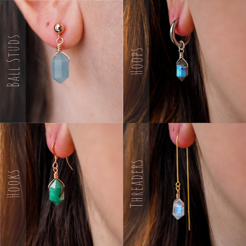 May include: Four different styles of earrings featuring gemstone pendants. The styles include ball studs, hoops, hooks, and threaders. The gemstones are blue, green, and iridescent.