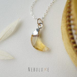 Peut inclure: Un collier en chaîne argent avec un pendentif en forme de croissant de lune en citrine jaune clair.
