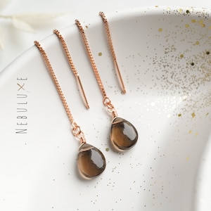 Puede incluir: Un par de pendientes colgantes de oro rosa con piedras de cuarzo ahumado en forma de lágrima.