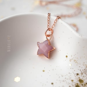 Peut inclure: Un collier en or rose avec un pendentif en forme d'étoile rose. Le pendentif est fait d'une pierre rose clair.