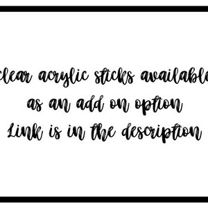May include: White background with a black border, featuring text in a cursive font. The text reads: "clear acrylic sticks available as an add on option Link is in the description."