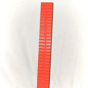 May include: A red plastic ruler with numbers 1 through 30 printed on it.
