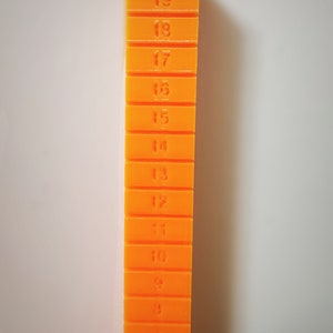 May include: A stack of orange plastic blocks with numbers 1 through 20 printed on them.