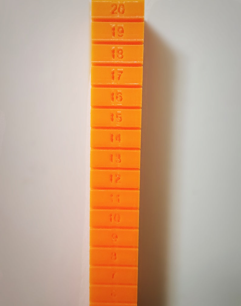 May include: A stack of orange plastic blocks with numbers 1 through 20 printed on them.