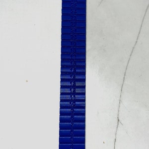 May include: A blue plastic ruler with numbers from 1 to 28 printed on it.