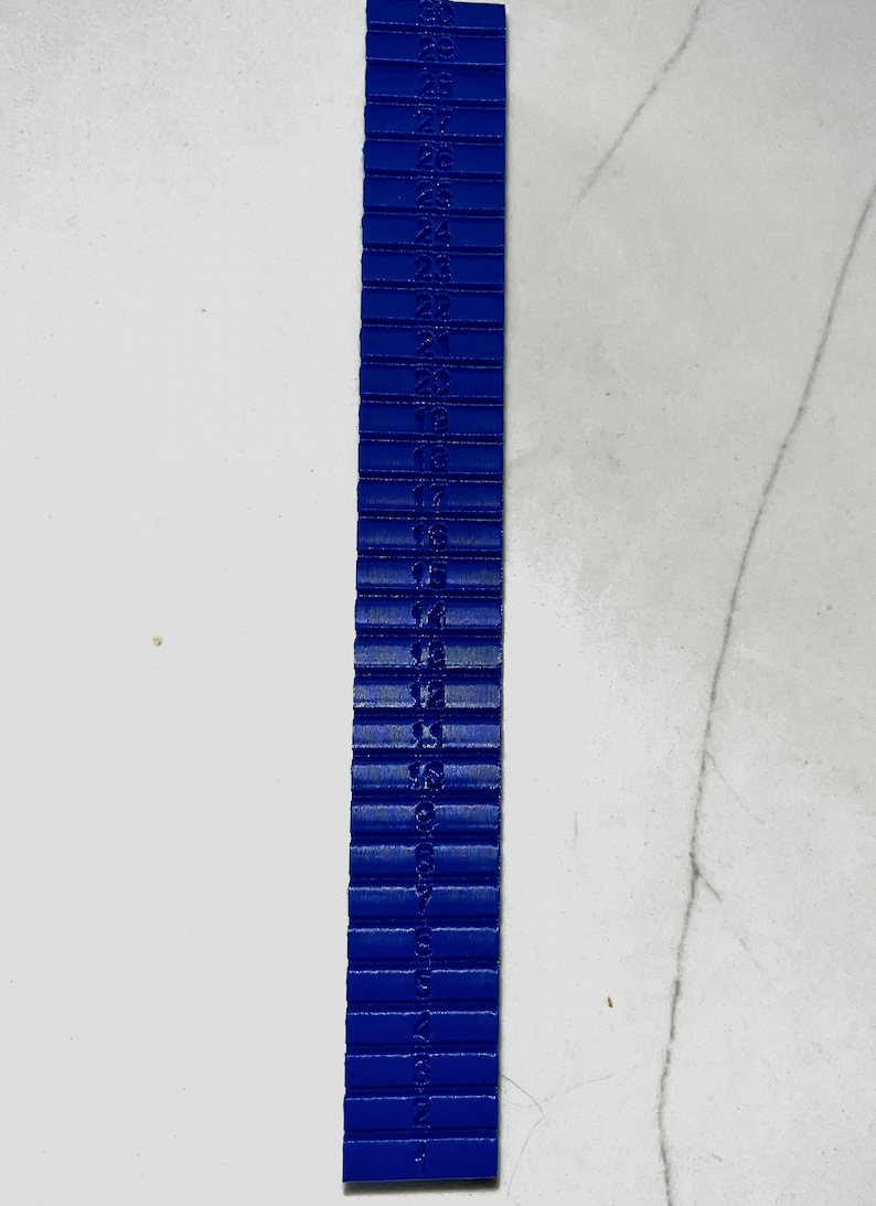 May include: A blue plastic ruler with numbers from 1 to 28 printed on it.