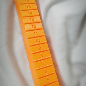 May include: Orange plastic ruler with numbers 2 through 20 printed on each section.