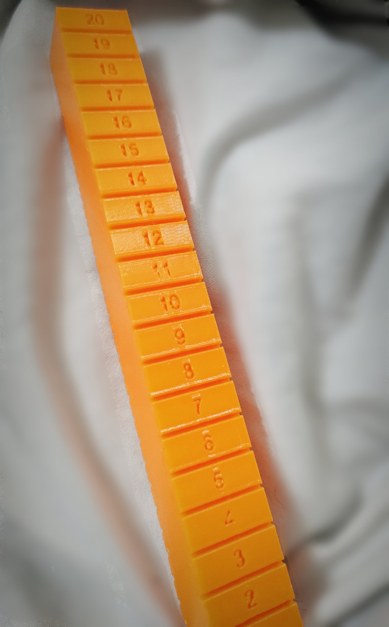 May include: Orange plastic ruler with numbers 2 through 20 printed on each section.
