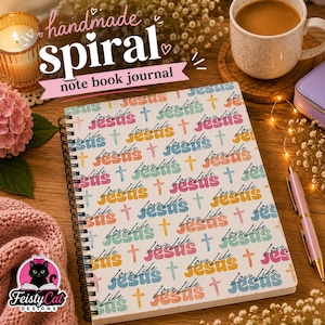 May include: A spiral-bound notebook journal featuring a repeating pattern of the word Jesus in pink, orange, and blue, interspersed with small crosses and the text Love Like in black script. The cover has a white background and black wire binding.