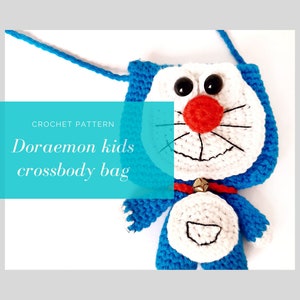 May include: Crochet pattern for a blue and white Doraemon kids crossbody bag. The bag features a smiling Doraemon face with black eyes, a red nose, and a white bell.