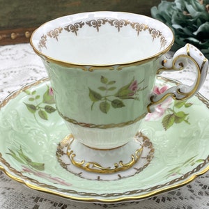 EB Foley mint green and gold with pink roses and buds tall and thin with raised pattern tea cup and saucer set. Vintage bone china England