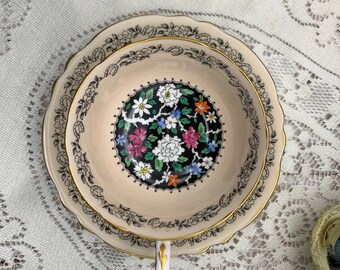 Paragon light peach with flowers over black with lucky horseshoe edge tea cup and saucer set. Vintage bone china England