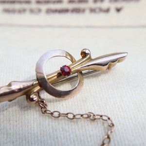 Antique Victorian Floral Bar Brooch featuring a central Garnet stone.